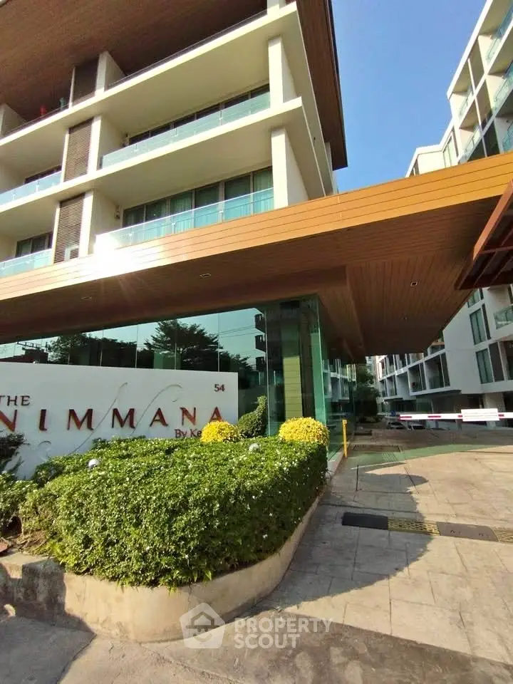 Modern condominium exterior with lush landscaping and sleek architectural design.