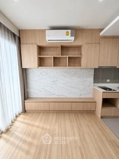 Modern living room with wooden flooring, built-in shelves, and air conditioning unit.