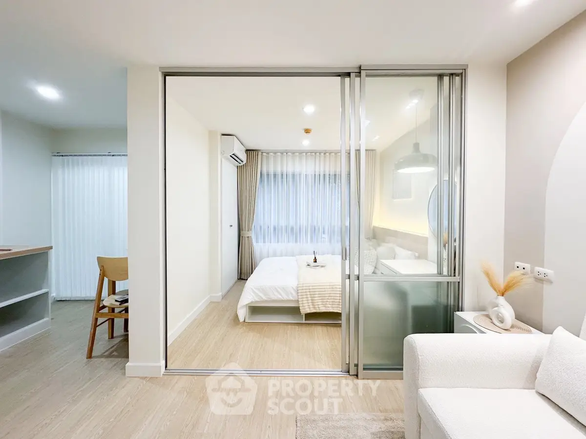 Modern open-layout bedroom with glass partition and cozy decor