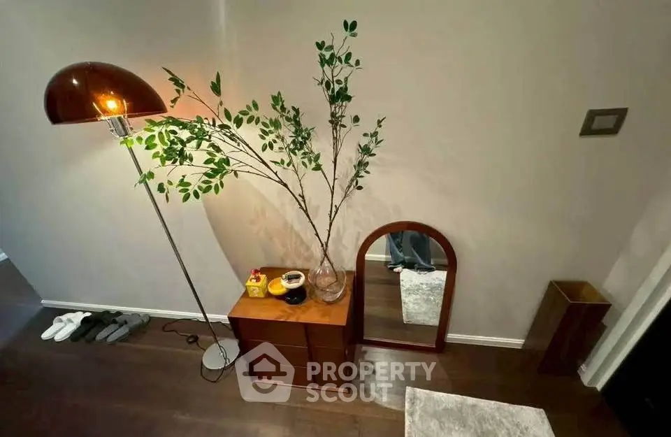 Stylish interior with modern floor lamp, decorative plants, and sleek wooden furniture.
