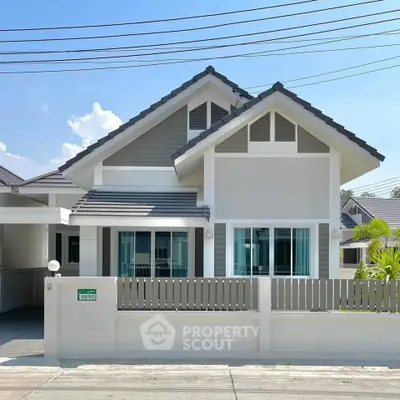 Charming modern house with gable roof and fenced yard in sunny neighborhood.
