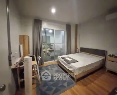 Spacious bedroom with modern decor and balcony access, featuring a cozy bed and stylish furnishings.