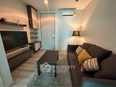 Cozy living room with modern decor, featuring a sleek TV unit and comfortable seating.