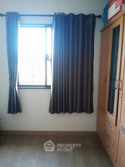 Cozy bedroom with wooden wardrobe and window view