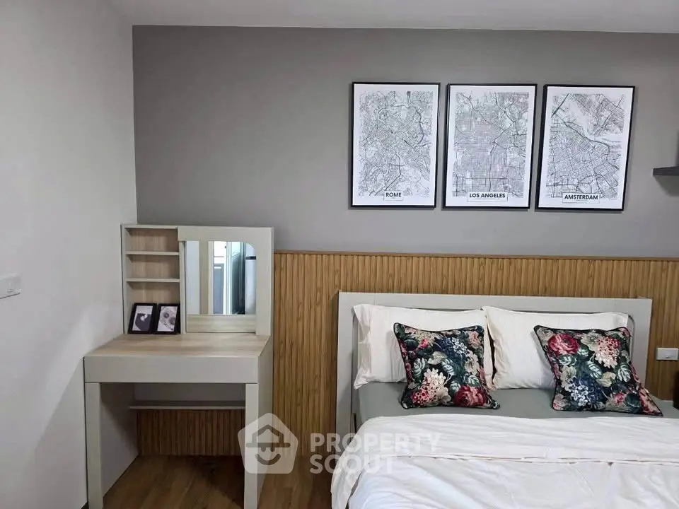 Chic bedroom with stylish decor and cozy bedding, featuring a modern vanity and city map artwork.