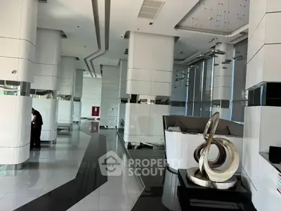 Luxurious modern building lobby with sleek design and artistic sculpture