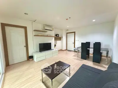 Spacious modern living room with dining area, featuring sleek furniture and bright lighting.