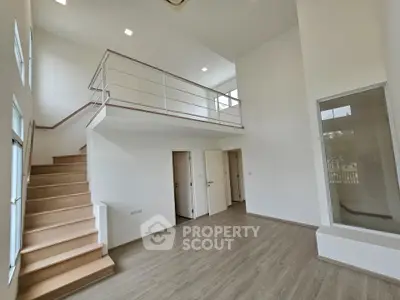 Spacious modern interior with high ceilings and mezzanine in a bright, open-plan home.