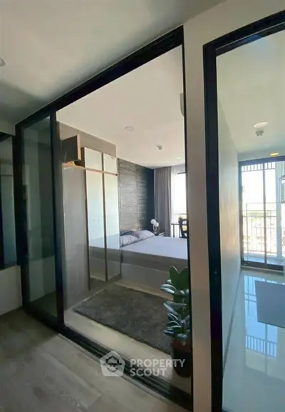 Modern bedroom with glass walls and balcony view in stylish apartment