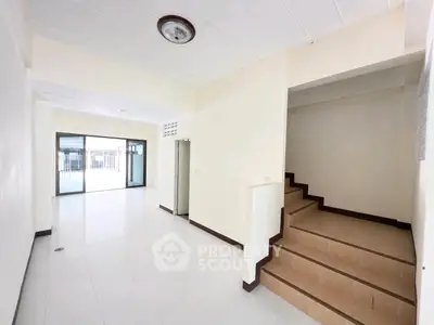 Spacious interior with tiled floors and staircase, ideal for modern living.