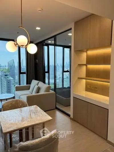 Modern living room with city view, elegant lighting, and stylish furniture in a high-rise apartment.