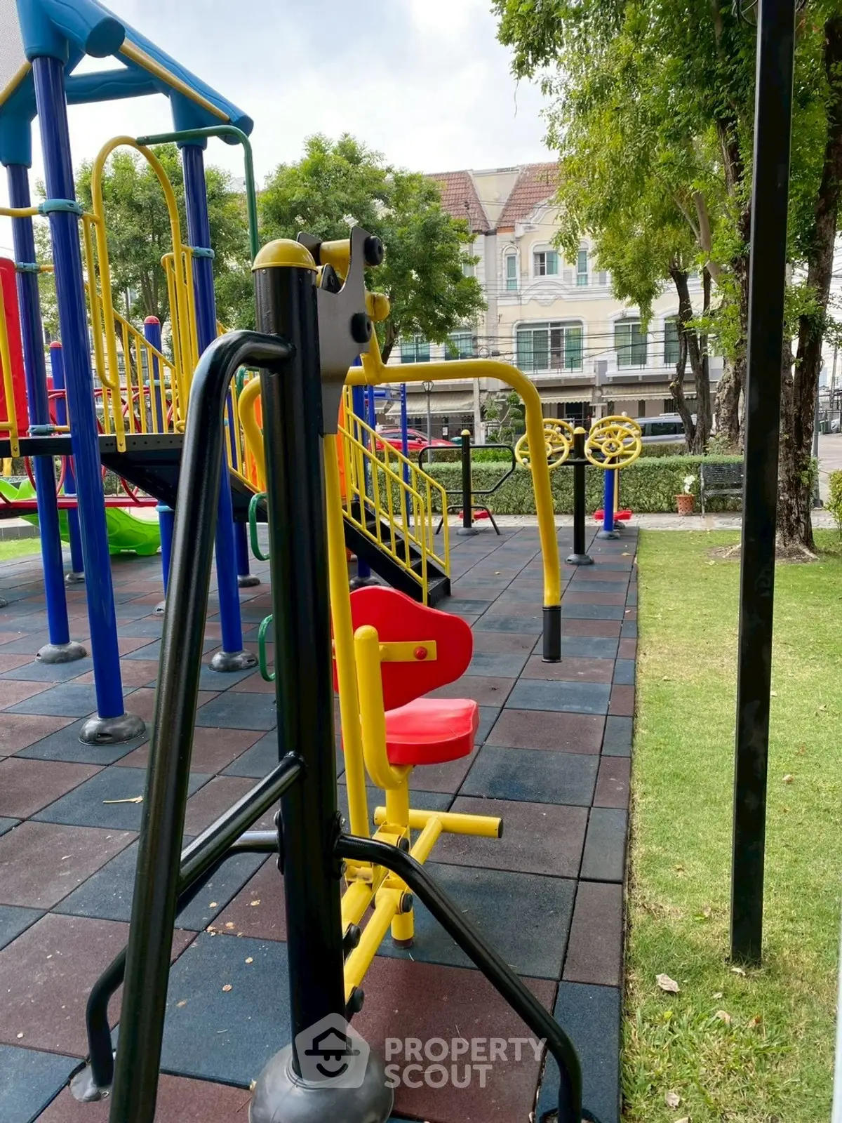 Vibrant playground area in a residential community with colorful equipment and lush greenery.