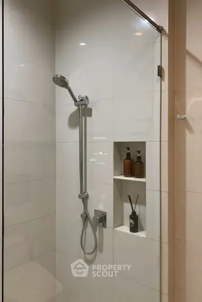 Modern bathroom shower area with sleek design and built-in shelves.