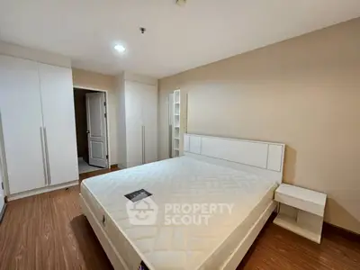 Spacious bedroom with modern design and ample storage in a cozy apartment.