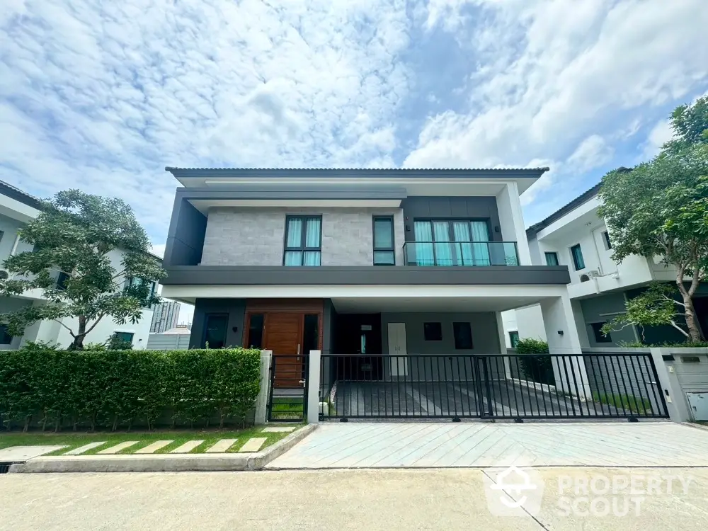 Modern two-story house with sleek design and spacious driveway in a serene neighborhood.