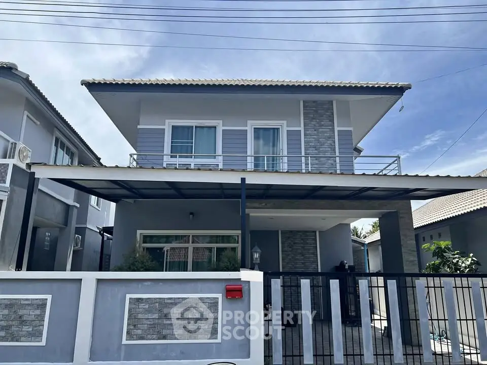 Modern two-story house with stylish facade and balcony in suburban neighborhood.