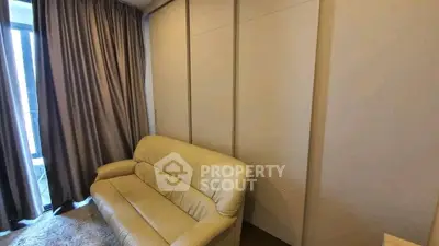 Cozy living room with beige sofa and floor-to-ceiling curtains, perfect for relaxation.
