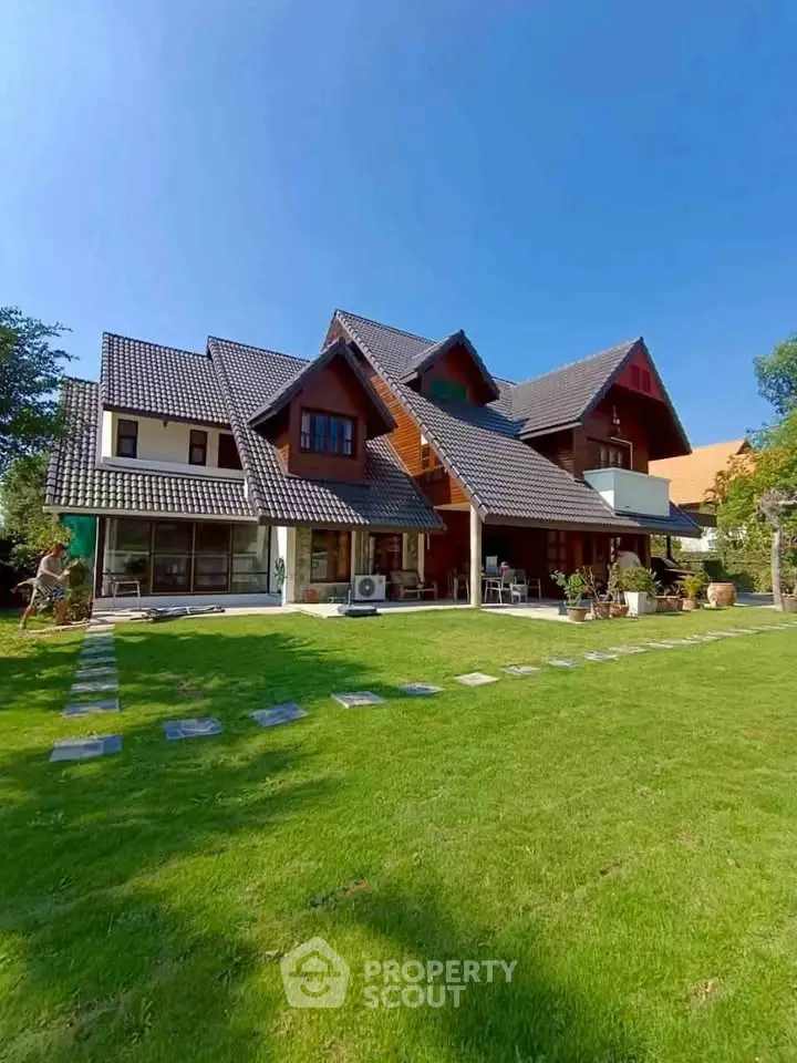 Charming modern house with lush green lawn and unique architectural design.