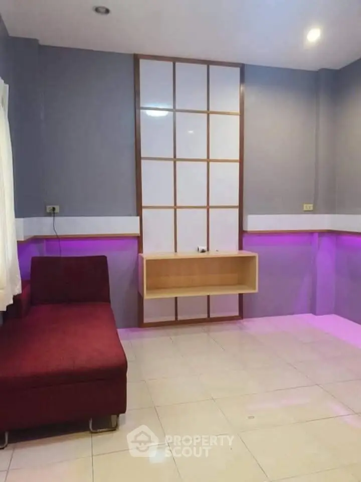 Modern living room with purple accent lighting and sleek design