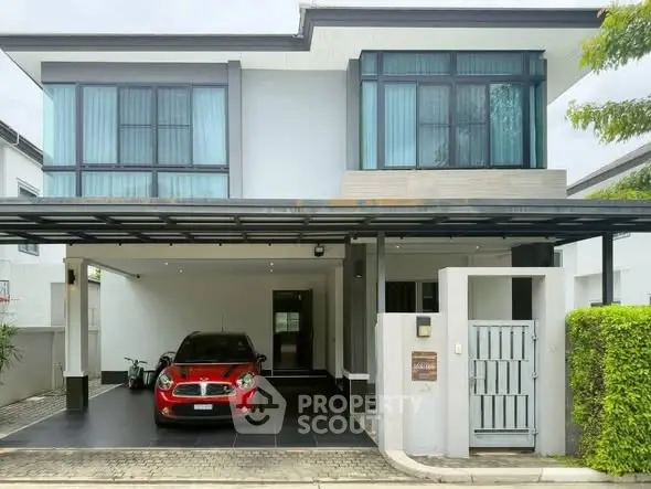 Modern two-story house with carport and red car parked in driveway.
