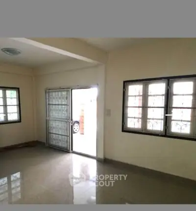Spacious living room with large windows and tiled flooring in a modern home.