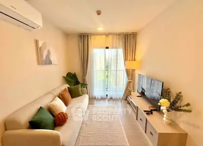 Cozy living room with modern decor and natural light, featuring a comfortable sofa and entertainment unit.