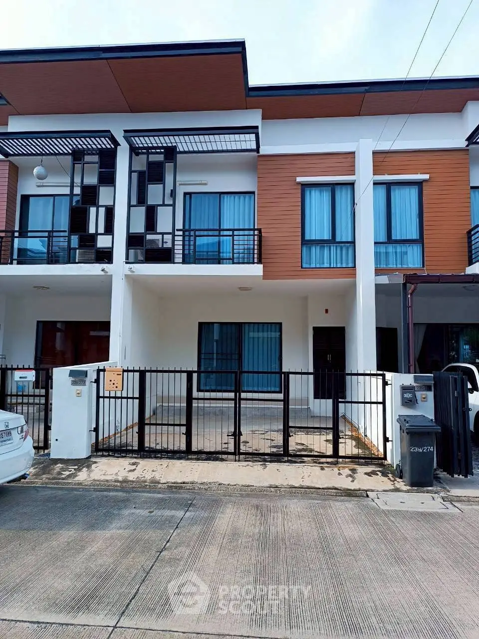 Modern townhouse exterior with sleek design and gated entrance in a suburban neighborhood.