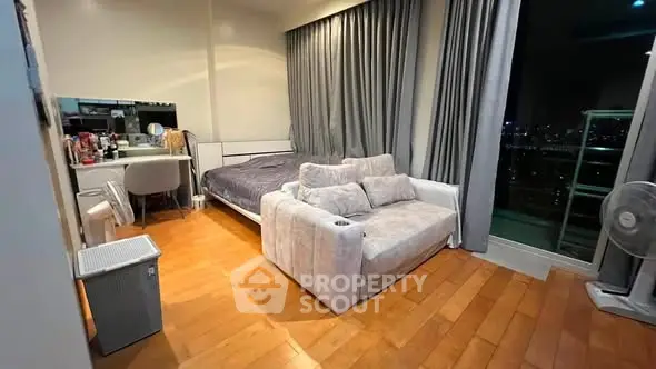 Spacious bedroom with cozy seating and city view balcony