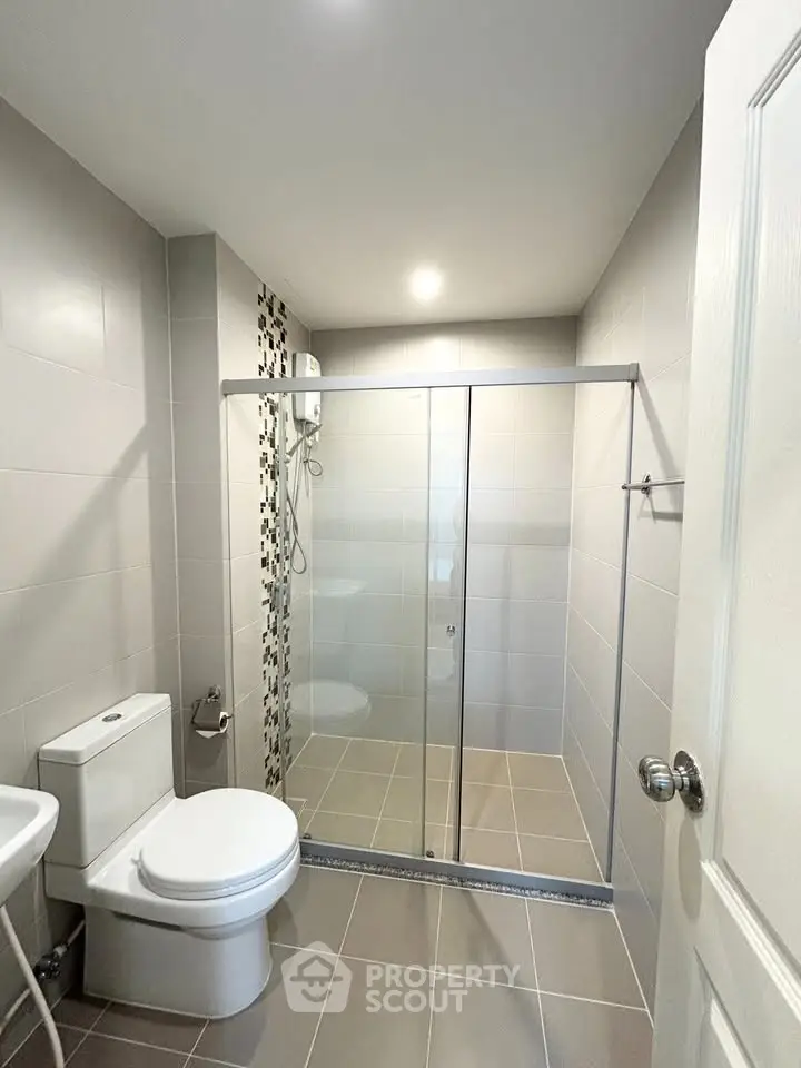 Modern bathroom with glass shower enclosure and sleek tile design