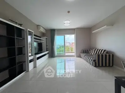 Spacious living room with modern furniture and large window offering a scenic view.