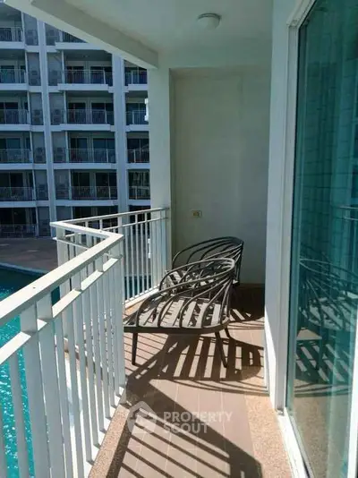 Charming balcony with pool view in modern apartment complex, perfect for relaxation and enjoying the outdoors.