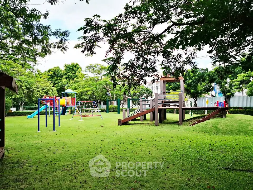 Spacious playground in a lush green garden setting, perfect for family-friendly living.