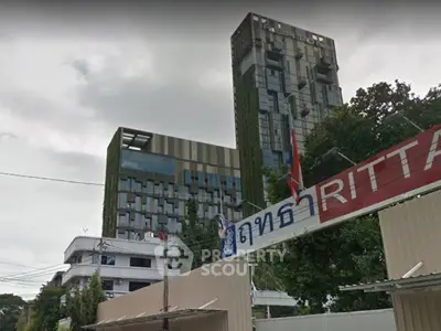 Modern urban building with unique architectural design and lush greenery facade.