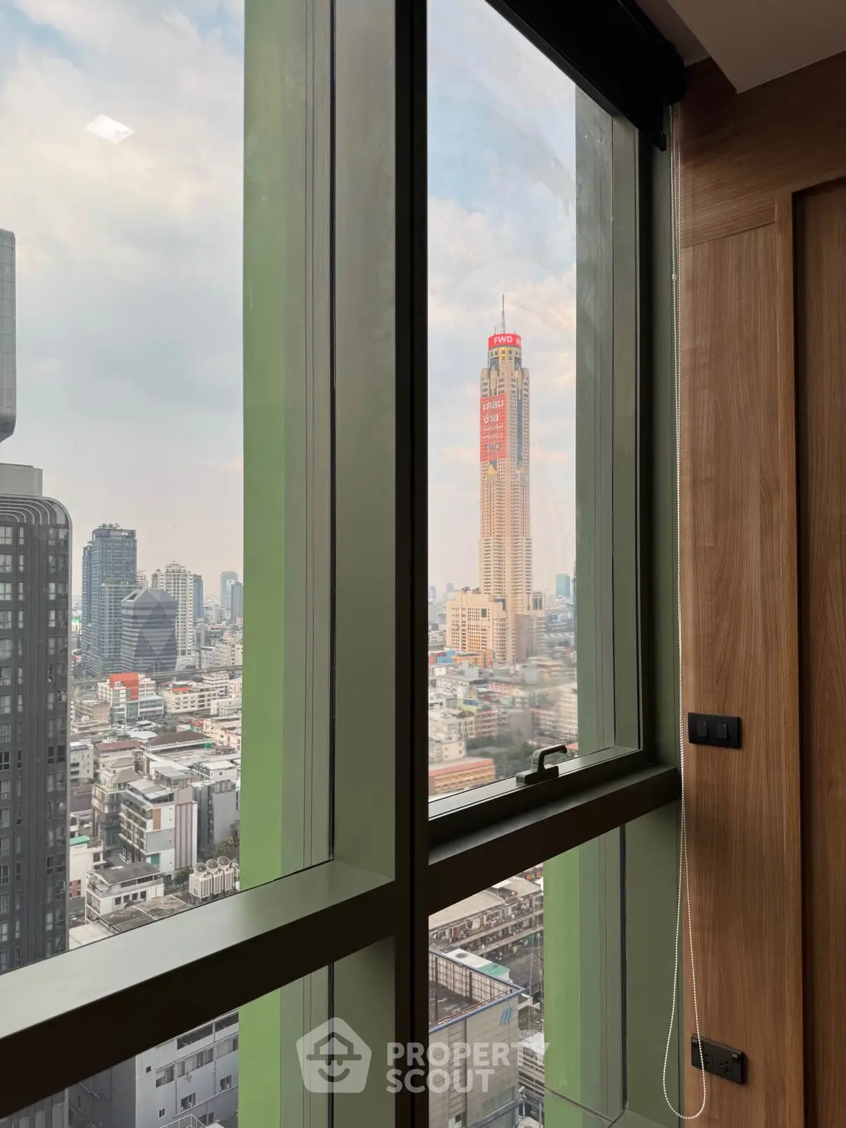 Stunning city view from high-rise apartment window with modern interior design.