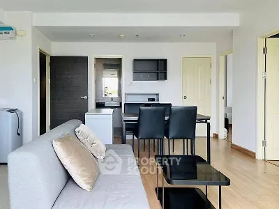 Modern living room with sleek furniture and open layout, featuring a cozy sofa and dining area.