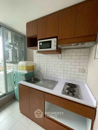 Modern compact kitchen with wooden cabinets and sleek appliances