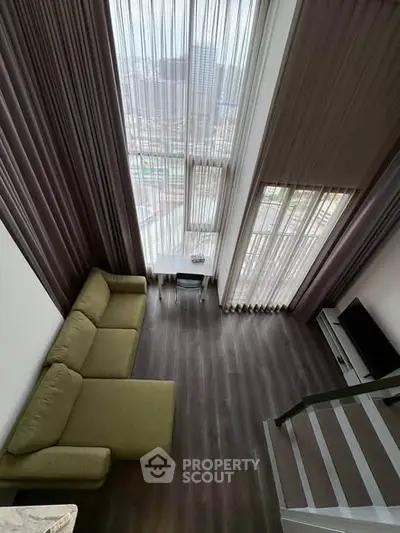 Stunning loft-style living room with high ceilings and panoramic city views.
