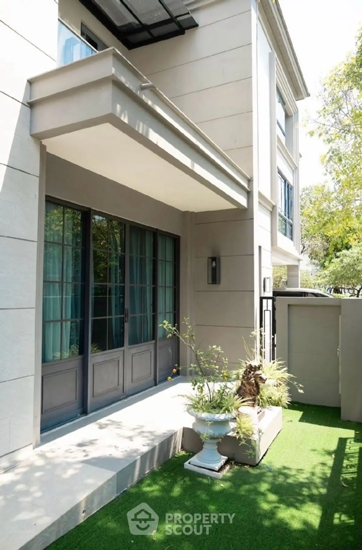 Elegant modern building exterior with lush garden and large windows