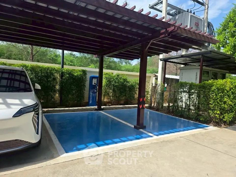 Modern parking area with electric vehicle charging station and sleek car under a stylish pergola.
