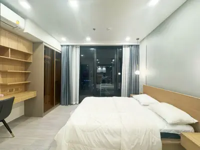Modern bedroom with sleek design, featuring built-in shelves and large windows for natural light.