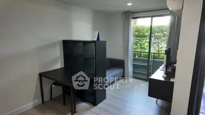 Modern living room with sleek furniture and balcony access, perfect for urban living.