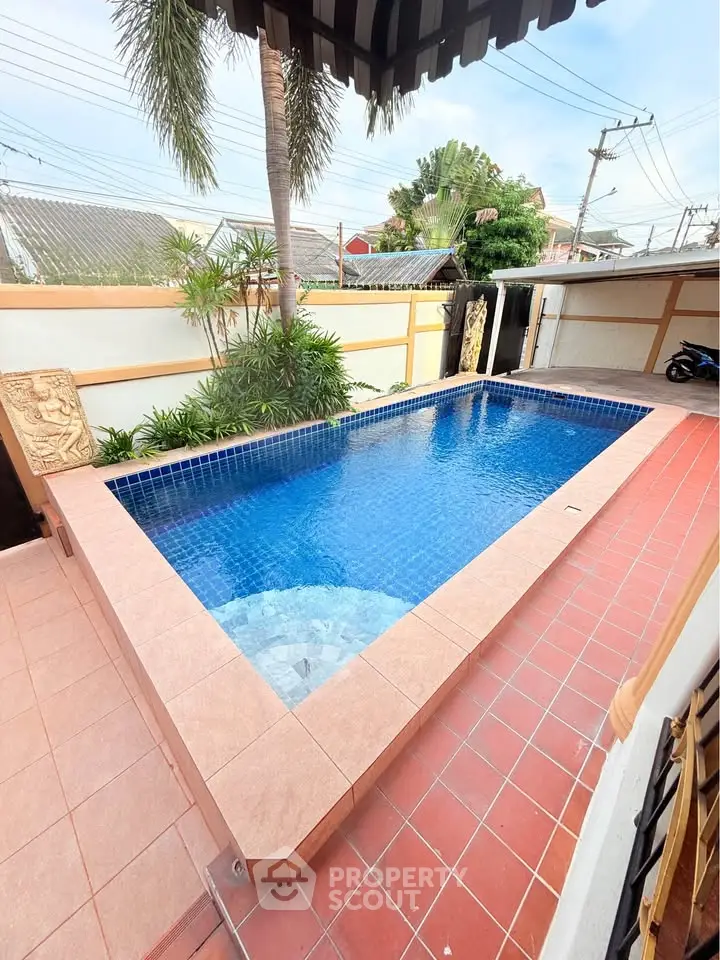 Stunning outdoor pool with tiled deck in a serene residential setting.