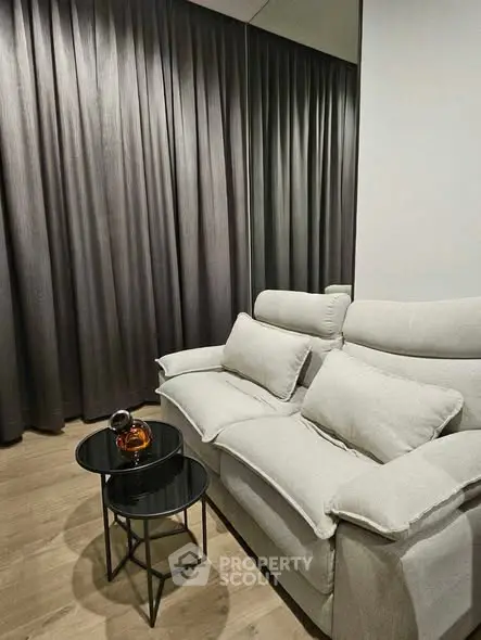 Cozy living room with plush sofa and elegant side tables, perfect for relaxation.