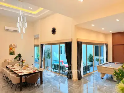 Luxurious open-plan living and dining area with pool table and elegant decor