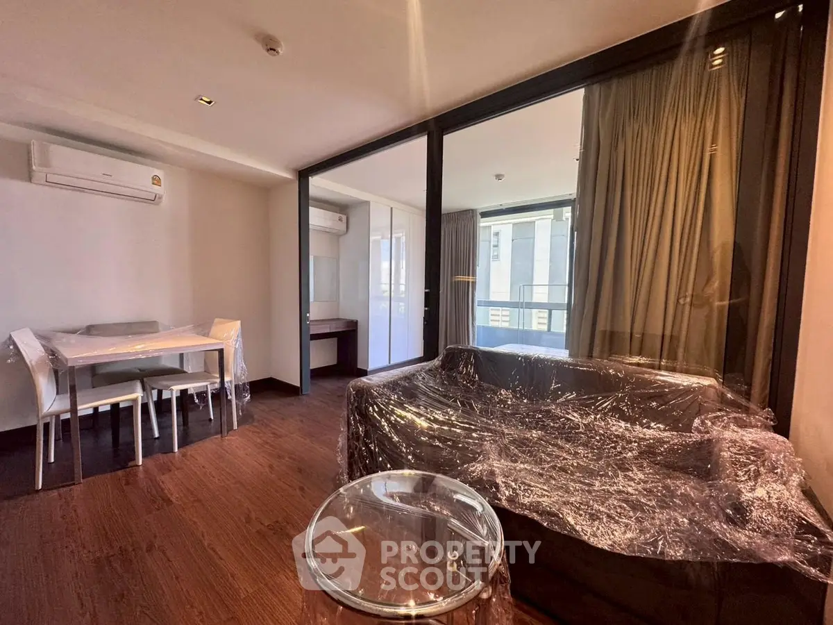 Modern living room with sleek furniture and large windows in a stylish apartment.