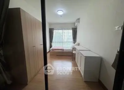 Cozy bedroom with large window and modern furnishings in a stylish apartment.
