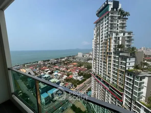 Stunning high-rise balcony view overlooking cityscape and ocean horizon.