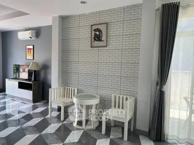 Modern living room with stylish decor and natural light, featuring elegant furniture and a sleek air conditioner.