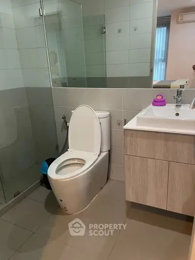 Modern bathroom with sleek fixtures and glass shower enclosure in a contemporary home.