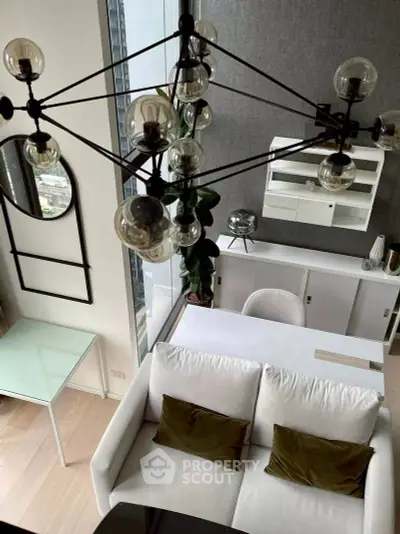 Modern living room with stylish chandelier and cozy white sofa